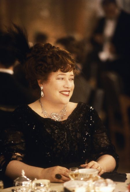 Kathy Bates portraying the role of Molly Brown in the film Titanic. She wears a classic black dress and looks quite young.