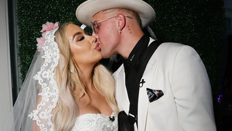 tana in a white wedding gown with jake in a white suit kissing on their wedding day