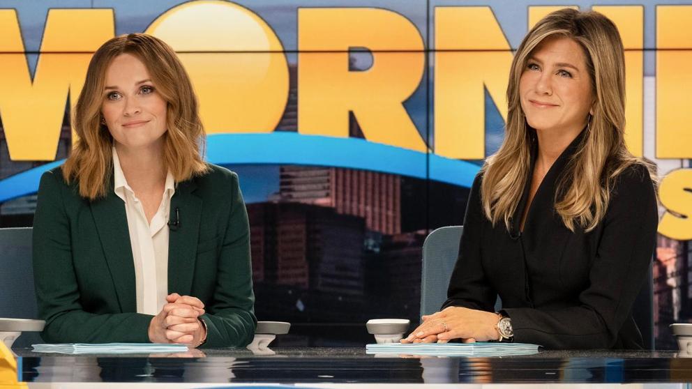 reese wearing a dark green suit and jennifer in a black shirt on the morning show