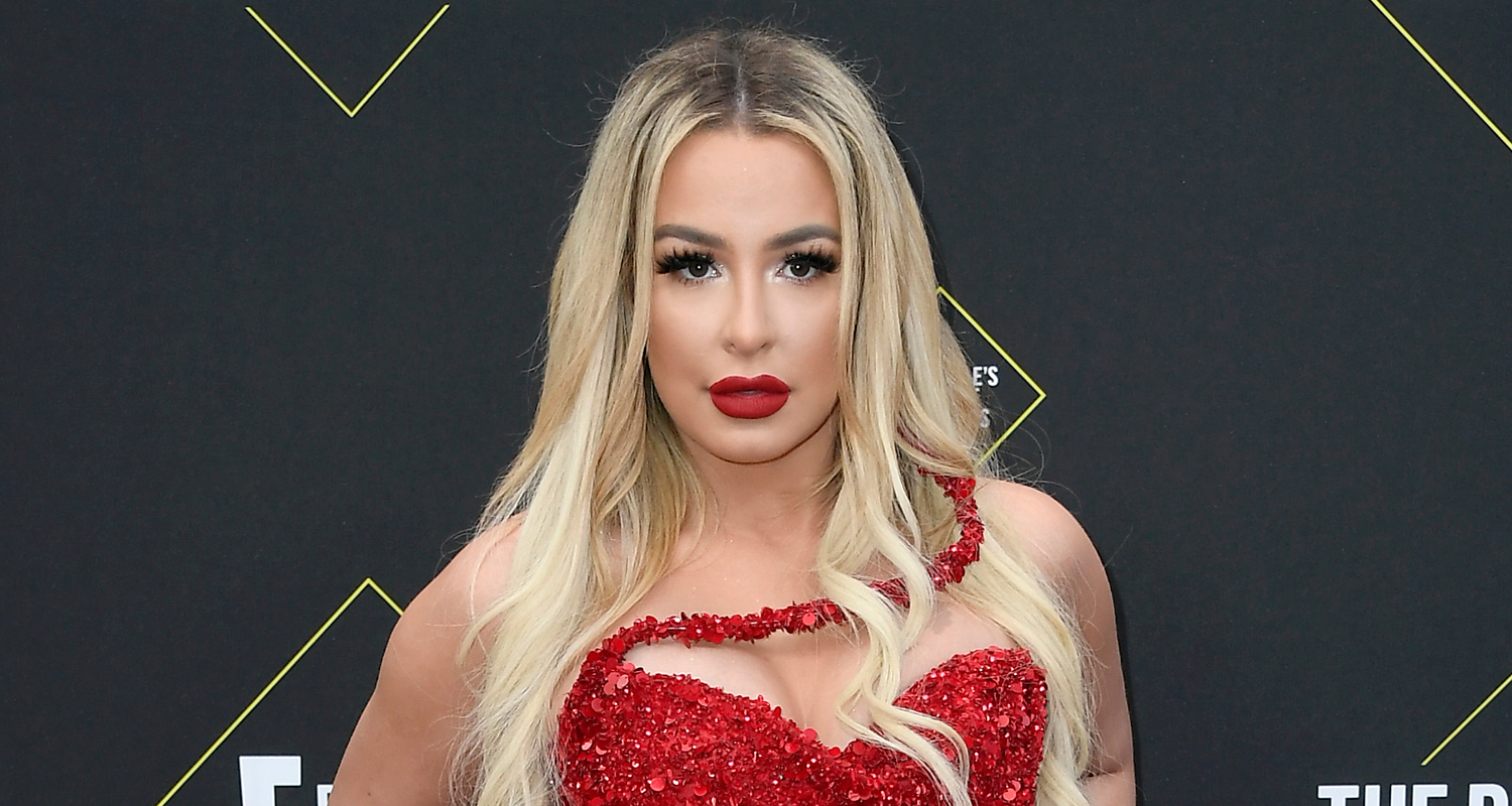 tana in a red beaded gown with bold red lip blonde hair and smokey eyes