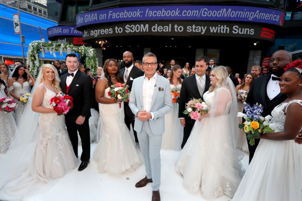 randy in a greyish suit with all the couples for the ceremony