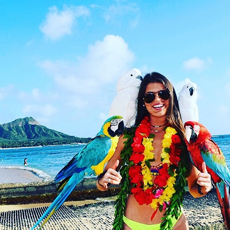 Madison Prewett with four birds on her hands and arms while vacationing in Hawaii.