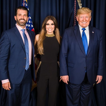 Kimberly Guilfoyle between boyfriend Donald Trump, Jr., and his father Donald Trump.