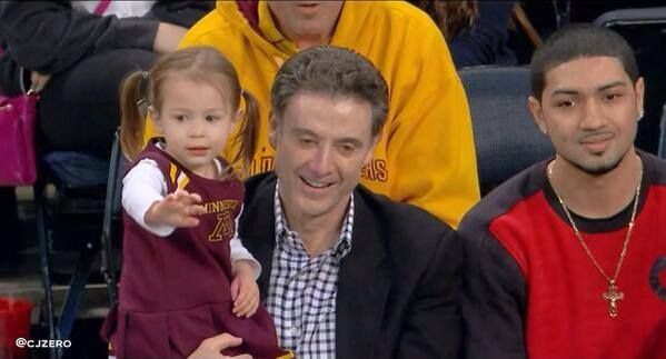 Rick Pitino in a black coat holding her grand-daughter.