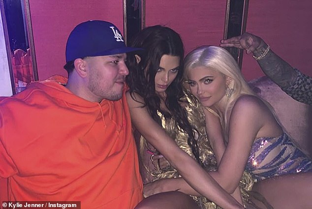 rob sitting on the couch along with kendal and kylie 