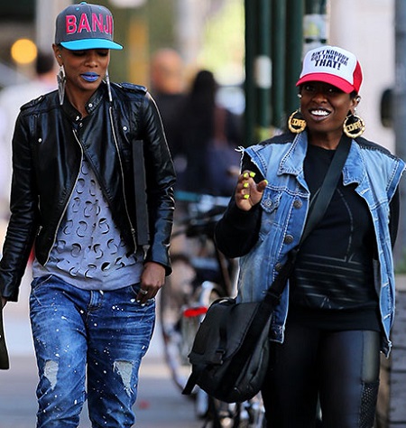 Missy Elliott and Sharaya J walking in the streets of New York with hats on.