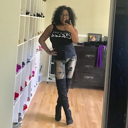 Sherri Shepherd taking a selfie in her closet in black top and ripped jeans.