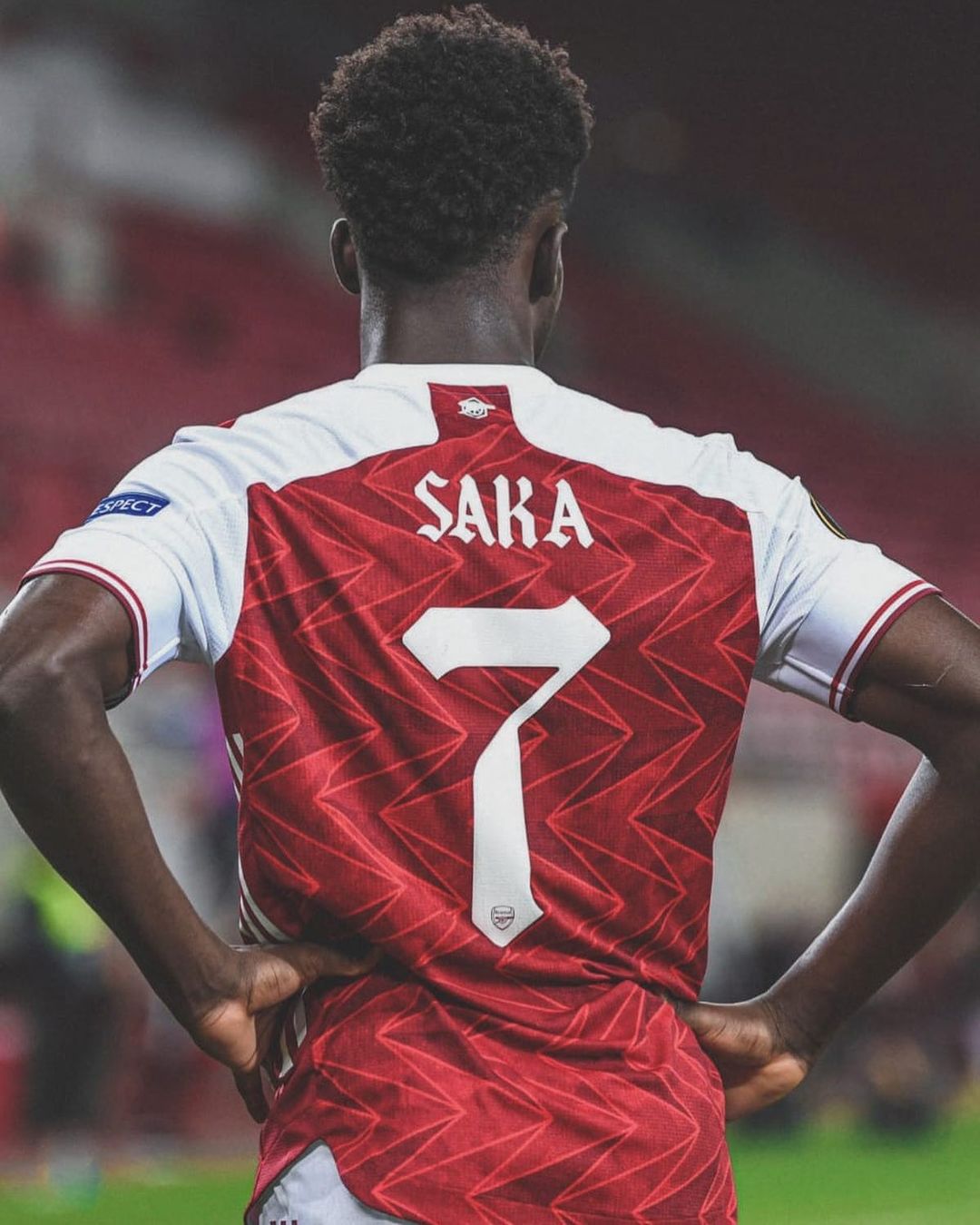 Bukayo Saka is showing his Jersey number 7.