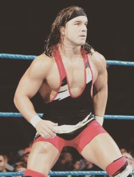 Chad Gable is posing at the ring.