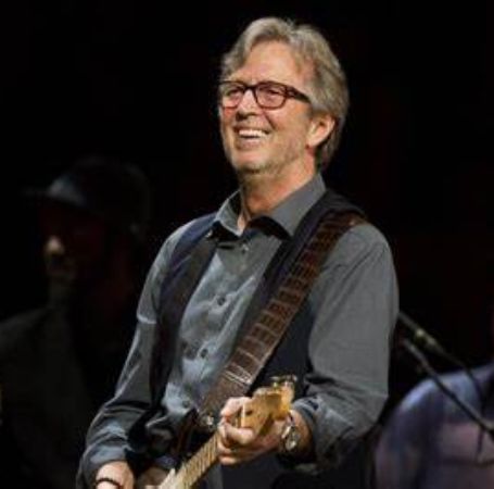Eric Clapton is playing guitar in his concert.
